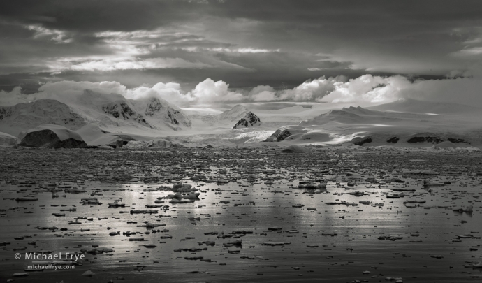 Clouds and mountains in an icy bay, Antarctica